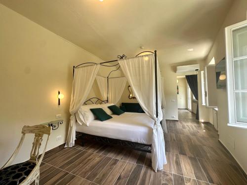 a bedroom with a canopy bed with green pillows at La Ninfa Hotel in Bagni di Lucca