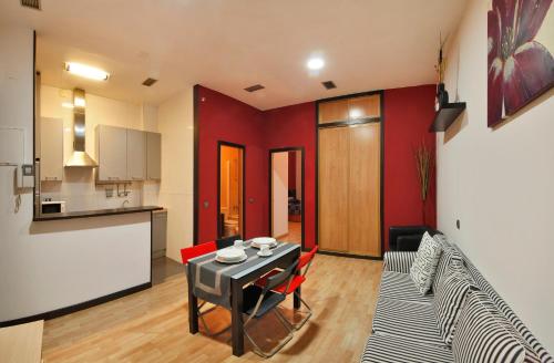 a kitchen and a living room with a table and chairs at Apartamentos El Tiempo in Madrid
