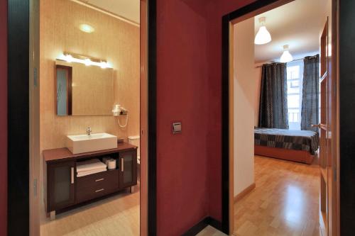 a bathroom with a sink and a mirror at Apartamentos El Tiempo in Madrid