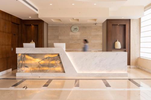 a lobby with a reception desk with a painting at Best Western Plus Amritsar in Amritsar