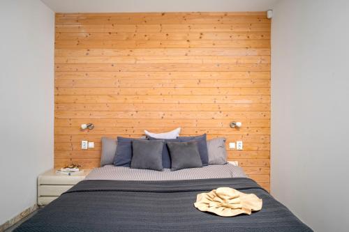 a bedroom with a large bed with a wooden wall at Sea Side Apart in Sinemorets