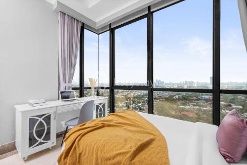 a bedroom with a bed and a desk and windows at Eterna by Kozystay - SCBD in Pondoklang