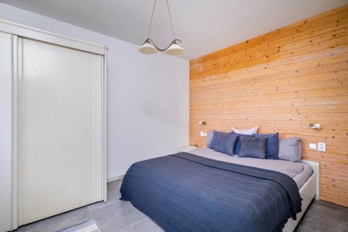 a bedroom with a bed and a wooden wall at Sea Side Apart in Sinemorets