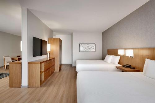 a hotel room with two beds and a television at Hyatt Place at Anaheim Resort / Convention Center in Anaheim