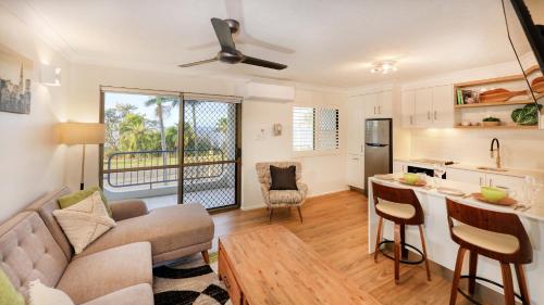 a living room with a couch and a kitchen at L'Amor Holiday Apartments in Yeppoon