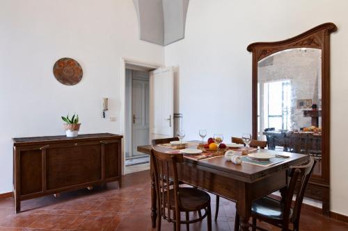 a dining room with a table and chairs and a kitchen at Casa Salento tre R - Lecce Selection in Squinzano