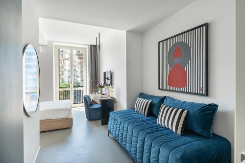 那不勒斯Le Mummarelle的客厅里有一张蓝色的沙发和一把椅子