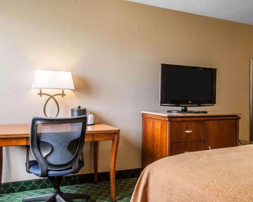 a room with a desk with a chair and a television at Quality Inn Cairo I-57 in Cairo