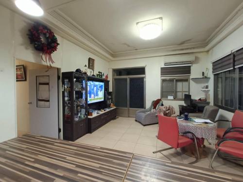 a living room with a tv and red chairs at 督督工作室民宿 in Nan-t'ien