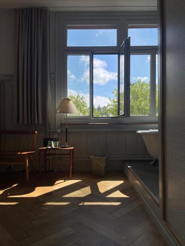 a room with a window and a table with a lamp at Militärkantine St. Gallen in St. Gallen