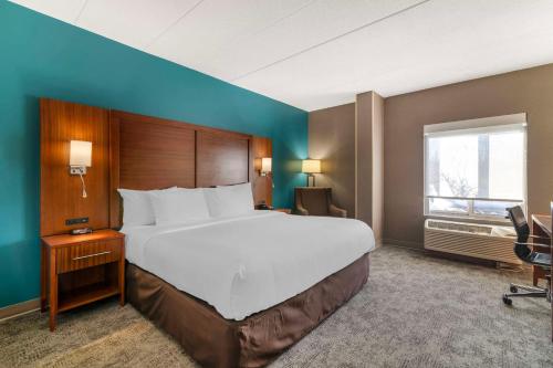 a hotel room with a large bed and a window at Comfort Inn Manchester Airport in Manchester