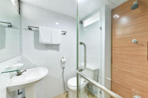 a bathroom with a toilet and a sink and a shower at Nice Palace Hotel in Bangkok