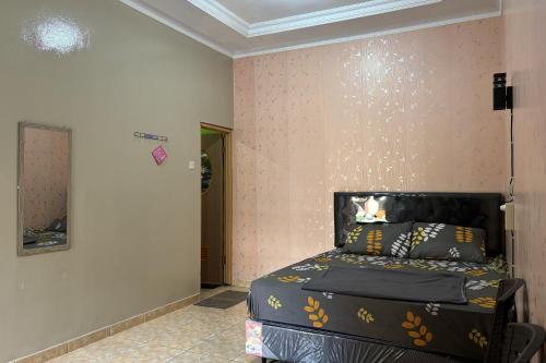 a bedroom with a bed in the corner of a room at Family 24 Hotel near Pantai Cipatujah in Cipatujah