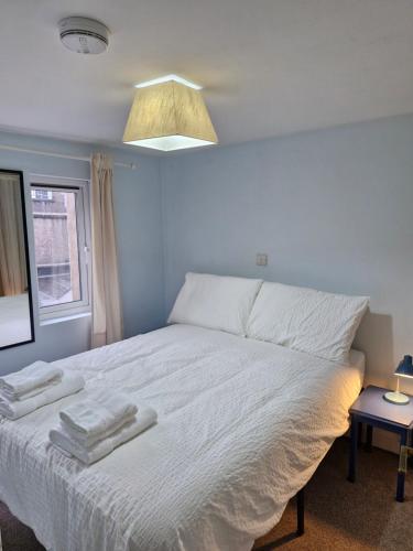 a bedroom with a white bed with towels on it at Model Cottages in Cork