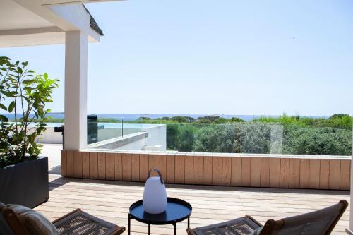 a patio with chairs and a table on a deck at Villa AzaiTu Suites in Porto-Vecchio