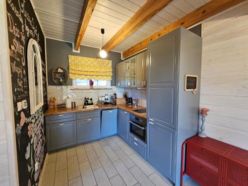 a kitchen with blue cabinets and a red bench at GłuszaSpot Dom Freja in Bytoń