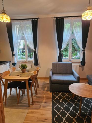 a living room with a couch and a table and chairs at Baltic Swans - Apartment in Sopot