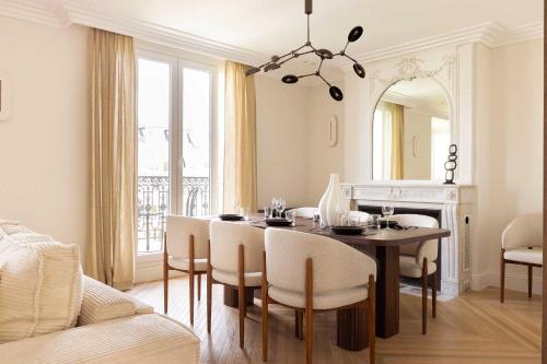 une salle à manger avec une table, des chaises et un miroir dans l'établissement Luxury apt - Eiffel Tower view - 3BD-8P - Grenelle, à Paris