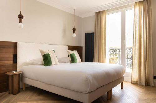 une chambre avec un grand lit blanc avec des oreillers verts dans l'établissement Luxury apt - Eiffel Tower view - 3BD-8P - Grenelle, à Paris