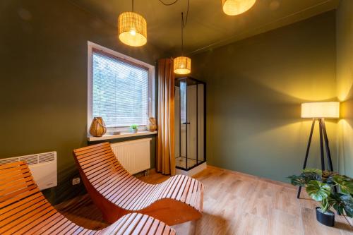 a living room with two chairs and a window at Awilla Ustka in Ustka