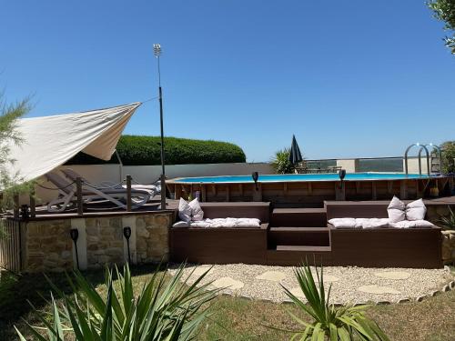 une terrasse avec deux canapés et une piscine dans l'établissement Coquelicot, à Montagnac