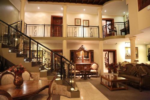 a large living room with a staircase and a table at Misty Waves Boutique Hotel in Hermanus