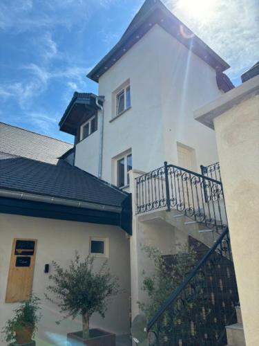 une maison blanche avec un balcon et un arbre dans l'établissement La tour du château, à Truison
