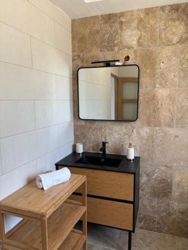 une salle de bain avec un lavabo noir et un miroir dans l'établissement La tour du château, à Truison