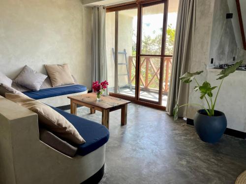 a living room with a couch and a table at Baobab Bungalows in Jambiani