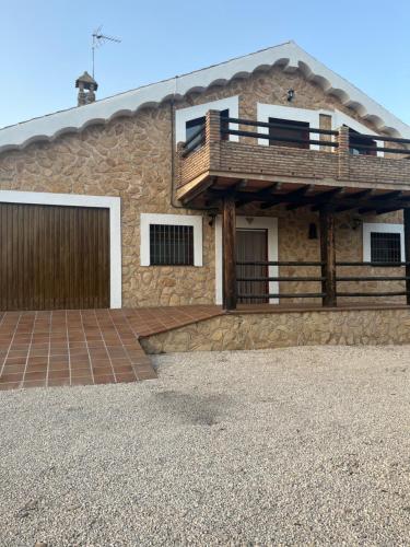 a stone house with a balcony on top of it at Tres deseos in Montefrío