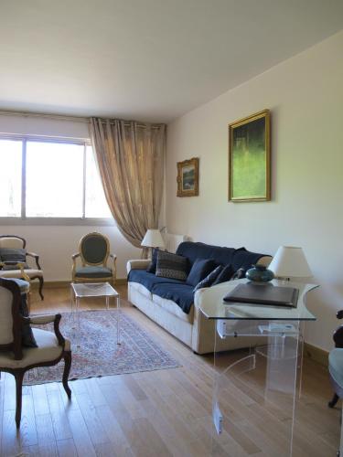 a living room with a blue couch and a table at Rue de Courcelles - Paris 8 in Paris