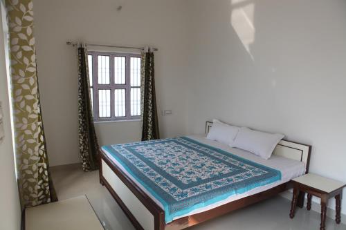 普什卡的住宿－Keshav Palace，一间卧室设有一张床和一个窗口