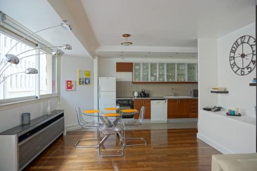 une cuisine avec une table et des chaises dans une pièce dans l'établissement Rue Beaujon - Paris 8, à Paris