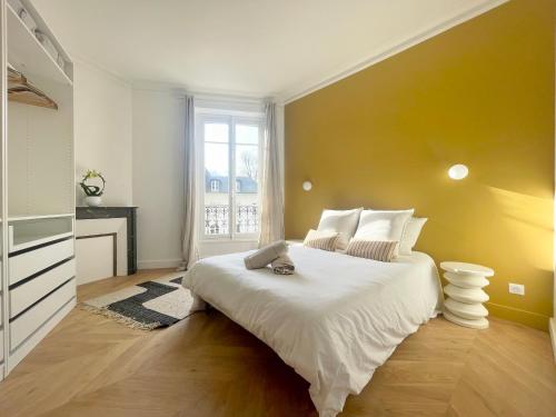 une chambre avec un grand lit blanc et une fenêtre dans l'établissement L'Orée du Château - Trianon Palace, à Versailles