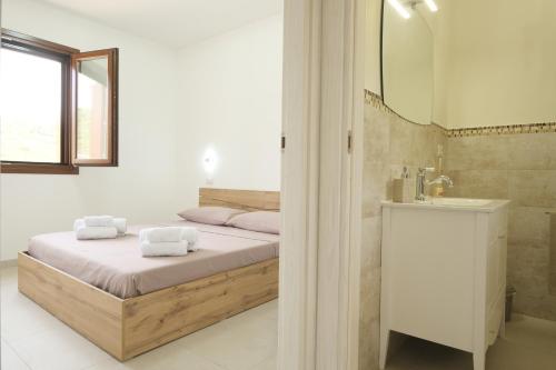 a bedroom with a bed and a sink and a mirror at Domus Aurea in Alghero