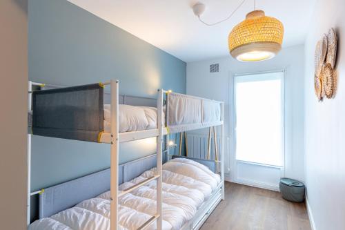 a room with two bunk beds and a light at Cocon de standing FACE MER 4 personnes in Pornichet