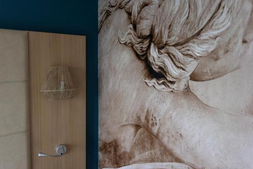 a painting of a woman on a wall next to a door at ibis Styles Chinon in Chinon