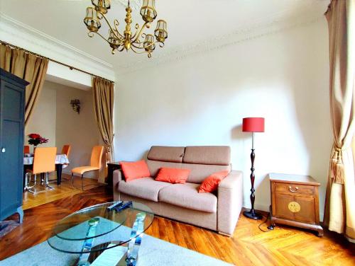 un salon avec un canapé et une table en verre dans l'établissement Bd de Grenelle - Paris 15, à Paris