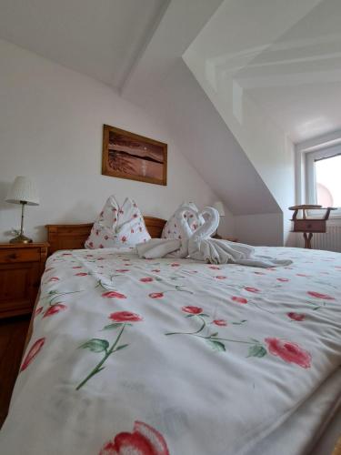 a large white bed with red flowers on it at Vila Harmónia in Turčianske Teplice