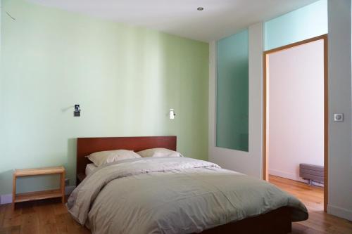 une chambre avec un grand lit avec une tête de lit en bois dans l'établissement Avenue de la Grande Armee - Paris 17, à Paris