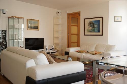 - un salon avec deux canapés blancs et une télévision dans l'établissement Rue de la Chaussée d'Antin - Paris 9, à Paris