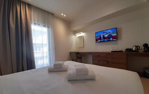 a hotel room with a bed with two towels at Elite Centre in Rhodes Town