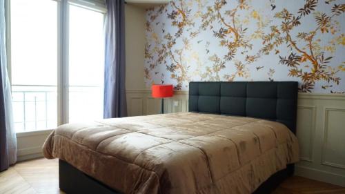 - une chambre avec un grand lit et une lampe rouge dans l'établissement Rue Poncelet - Paris 17, à Paris