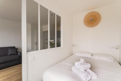 - une chambre blanche avec des serviettes blanches sur un lit dans l'établissement L'Escale Panoramique - Appt vue mer à Dinard, à Dinard