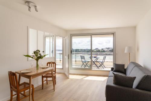 un salon avec une table et un canapé dans l'établissement L'Escale Panoramique - Appt vue mer à Dinard, à Dinard