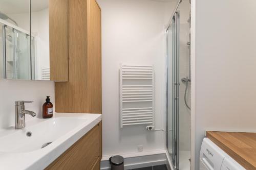 une salle de bain avec un lavabo et une douche dans l'établissement L'Escale Panoramique - Appt vue mer à Dinard, à Dinard