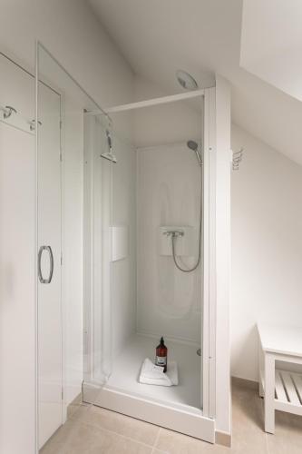 une salle de bain blanche avec une douche et un lavabo dans l'établissement Le Cap Catamaran - Maison pour 6p à Cancale, à Cancale