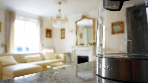 une cuisine et un salon avec un appareil sur un comptoir dans l'établissement Rue Lauriston - Paris 16, à Paris