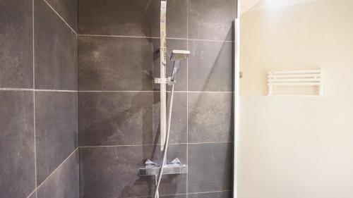 une douche avec une porte vitrée dans une salle de bain dans l'établissement Rue Lauriston - Paris 16, à Paris