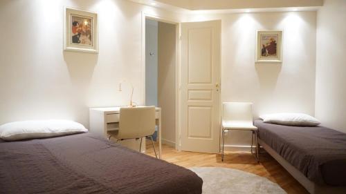 Cette chambre comprend deux lits et un bureau. dans l'établissement Rue Lauriston - Paris 16, à Paris